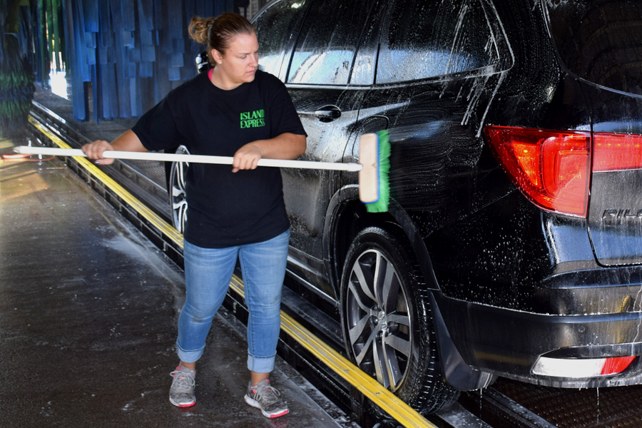 island express lube and car wash attendant pre-scrubbing a car